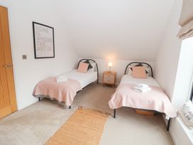 A bedroom with two single beds and a bedside table at Salt Marsh House, Southwold