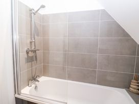 A bathroom with a bathtub and shower at Salt Marsh House, Southwold