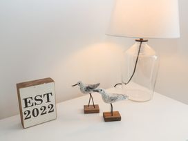 A table with birds, lamp and a block with EST 2022 at Salt Marsh House, Southwold