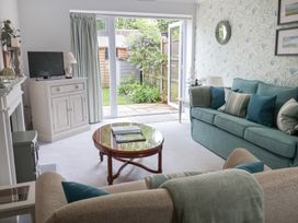 A living room with a television and sofa at 1 Coconut Cottage in Long Melford