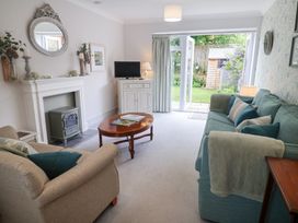 A living room with a sofa, coffee table and television at 1 Coconut Cottage, Long Melford