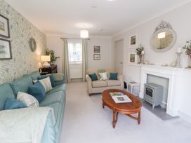 A living room with a sofa, armchair, and coffee table at 1 Coconut Cottage, Long Melford