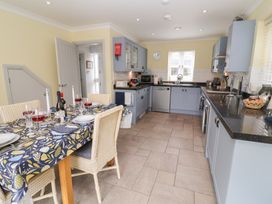 A kitchen with a dining table set for a meal at 1 Coconut Cottage, Long Melford
