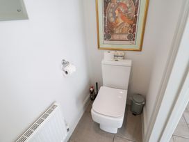 A bathroom featuring a toilet and decorative artwork at 1 Coconut Cottage, Long Melford