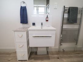 A bathroom with a sink and storage at 1 Coconut Cottage, Long Melford