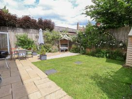 A garden with grass and seating area at 1 Coconut Cottage, Long Melford