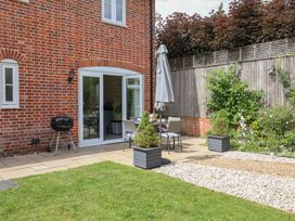 A garden with a table and chairs near the house at 1 Coconut Cottage, Long Melford