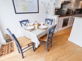 A kitchen dining area with a table set for four people with plates glasses of orange juice and croissants at Dolphin Cottage Southwold