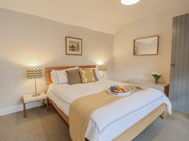 A bedroom with a bed and a bedside table at Fig Cottage, Pettistree