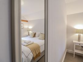 A bedroom with a bed and lamp at Fig Cottage, Pettistree Near Woodbridge