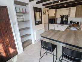 A kitchen with bar stools and open shelves at Candle Croft in Tolgus Mount near Redruth