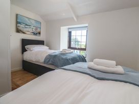 A bedroom with two single beds and a window at Candle Croft in Tolgus Mount near Redruth