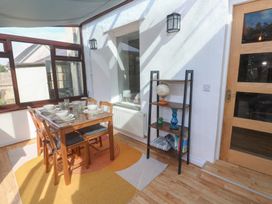 A conservatory with a dining table and chairs at Candle Croft in Tolgus Mount near Redruth
