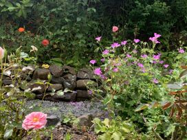 A garden with various flowers and stones at Rose Cottage in Okehampton