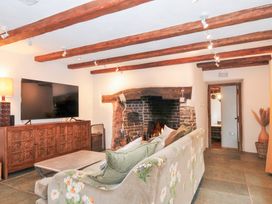 A living room with a television and a fireplace at Rose Cottage Okehampton