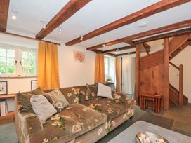 A living room with a sofa and staircase at Rose Cottage Okehampton
