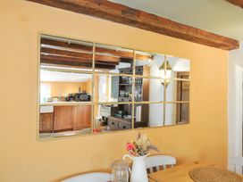 A mirror above a table with a jar at Rose Cottage in Okehampton