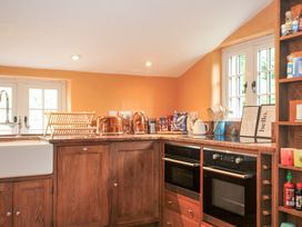 A kitchen with a sink, oven, and dish rack at Rose Cottage Okehampton