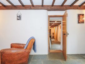 A snug area with a chair and a door leading to another room at Rose Cottage Okehampton