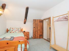 A bedroom with a bed and wardrobe at Rose Cottage in Okehampton