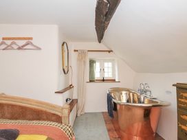 A bathroom with a copper bathtub and window at Rose Cottage Okehampton