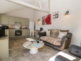 A living room with kitchen area and seating at Bottom Lodge in Penhow