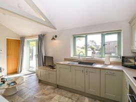 A kitchen with cabinets and a sink at Bottom Lodge in Penhow