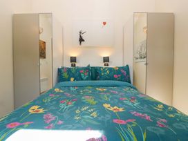 A bedroom with a bed and two wardrobe doors at Bottom Lodge in Penhow