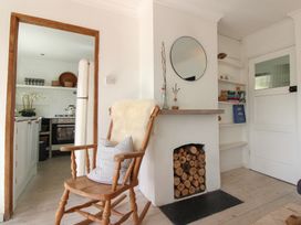 A living room with a rocking chair and wood storage at West Island in Kingsbridge