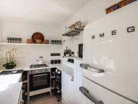 A kitchen with a refrigerator, oven, stove, and utensils at West Island in Kingsbridge