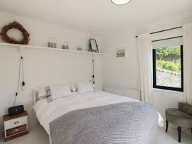 A bedroom with a bed and shelf at West Island in Kingsbridge