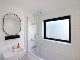 A bathroom with a shower, mirror, and sink at West Island in Kingsbridge