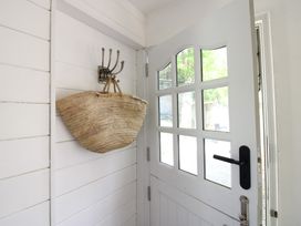 An entryway with a door and a basket hanging on a hook at West Island in Kingsbridge