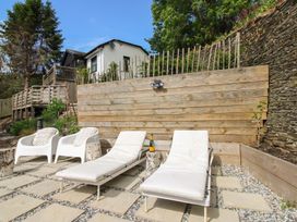 An outdoor area with lounge chairs and a bottle on a table at West Island in Kingsbridge