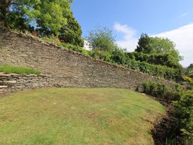 A garden with a stone wall and grass at West Island in Kingsbridge