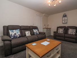 A living room with two brown sofas a wooden coffee table and a cabinet with nautical decor at Happy Days in Bridlington