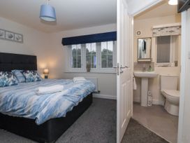 A bedroom with a double bed and an ensuite bathroom at Happy Days in Bridlington