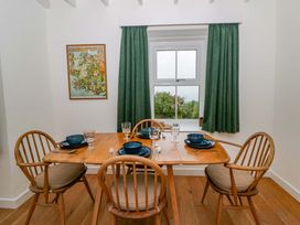 A dining room with a wooden table set for dinner at Ceunant near Newport