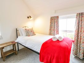 A bedroom with a bed and bedside table at Ceunant near Newport