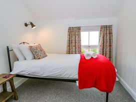 A bedroom with a bed and patterned curtains at Ceunant near Newport