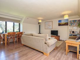 A living room with a sofa and dining area at The Mews in Blisland