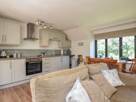 A kitchen with an oven and dining table at The Mews in Blisland