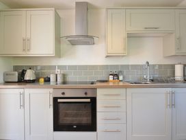 A kitchen with cabinets, oven, sink, and appliances at The Mews in Blisland