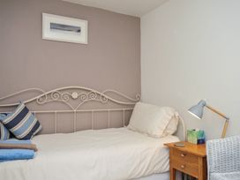 A bedroom with a bed and nightstand at The Mews in Blisland