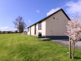 A house with grass and a tree at Sunny Cottage in Brecon