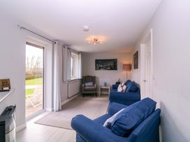 A living room with blue sofas and a coffee table at Sunny Cottage in Brecon