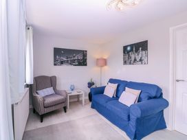 A living room with a sofa and armchair at Sunny Cottage in Brecon