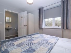 A bedroom with a bed and door leading to a bathroom at Sunny Cottage in Brecon