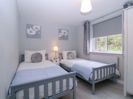 A bedroom with two beds and a lamp at Sunny Cottage in Brecon