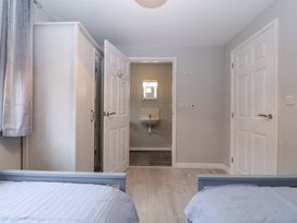 A bedroom with a bed and wardrobe at Sunny Cottage in Brecon
